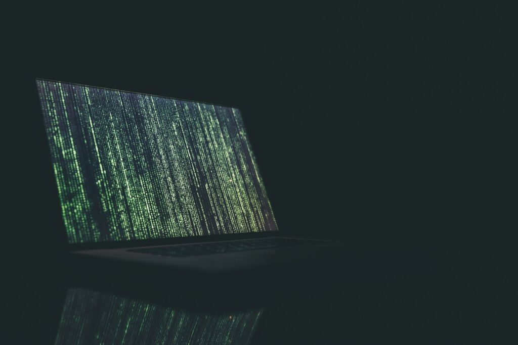 A laptop screen glowing in a darkened room, representing browser data collection and online privacy